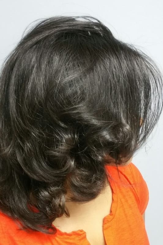 Glossy shoulder-length silk press with soft curled ends
