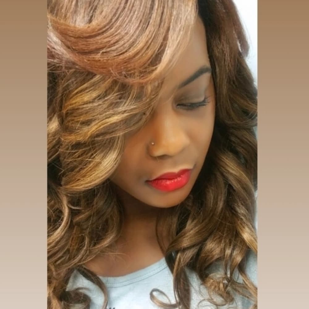 Classic sew-in with flowing caramel-highlighted curls